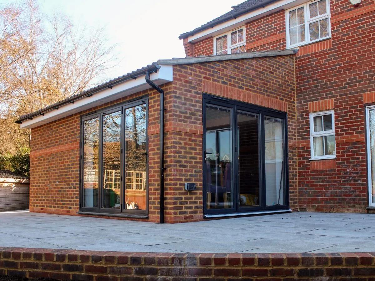 Brick extension with wide glazed doors opening onto a terrace